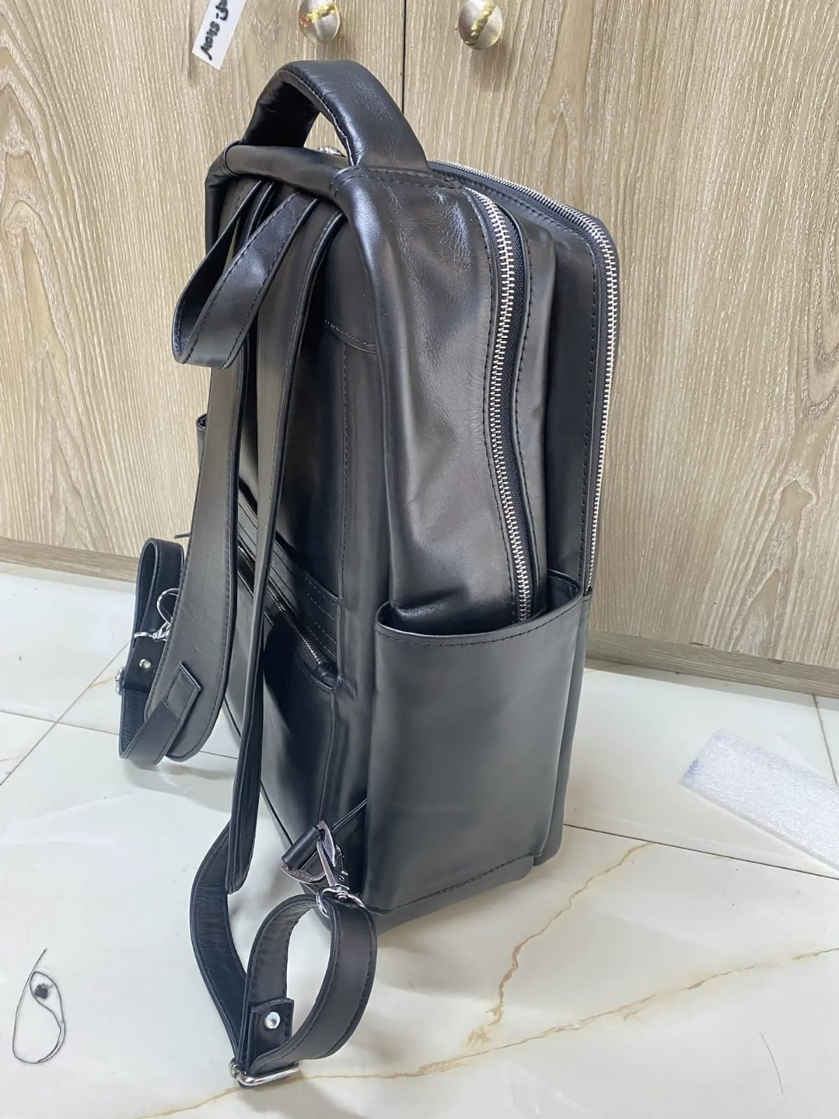 Genuine black leather laptop backpack with padded straps and side pockets Genuine black leather laptop backpack with padded straps and side pockets