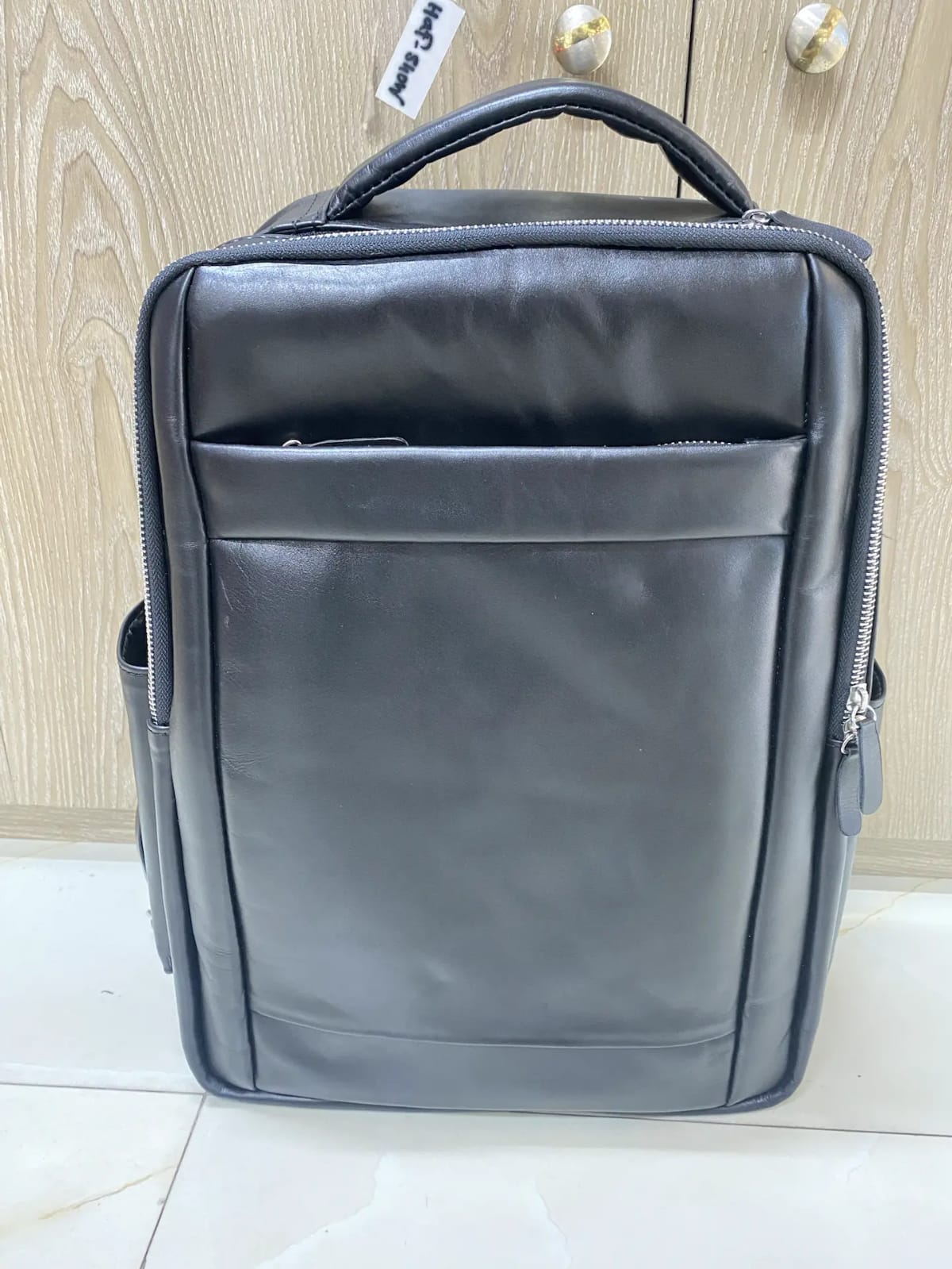 Genuine black leather laptop backpack with padded straps and side pockets Genuine black leather laptop backpack with padded straps and side pockets