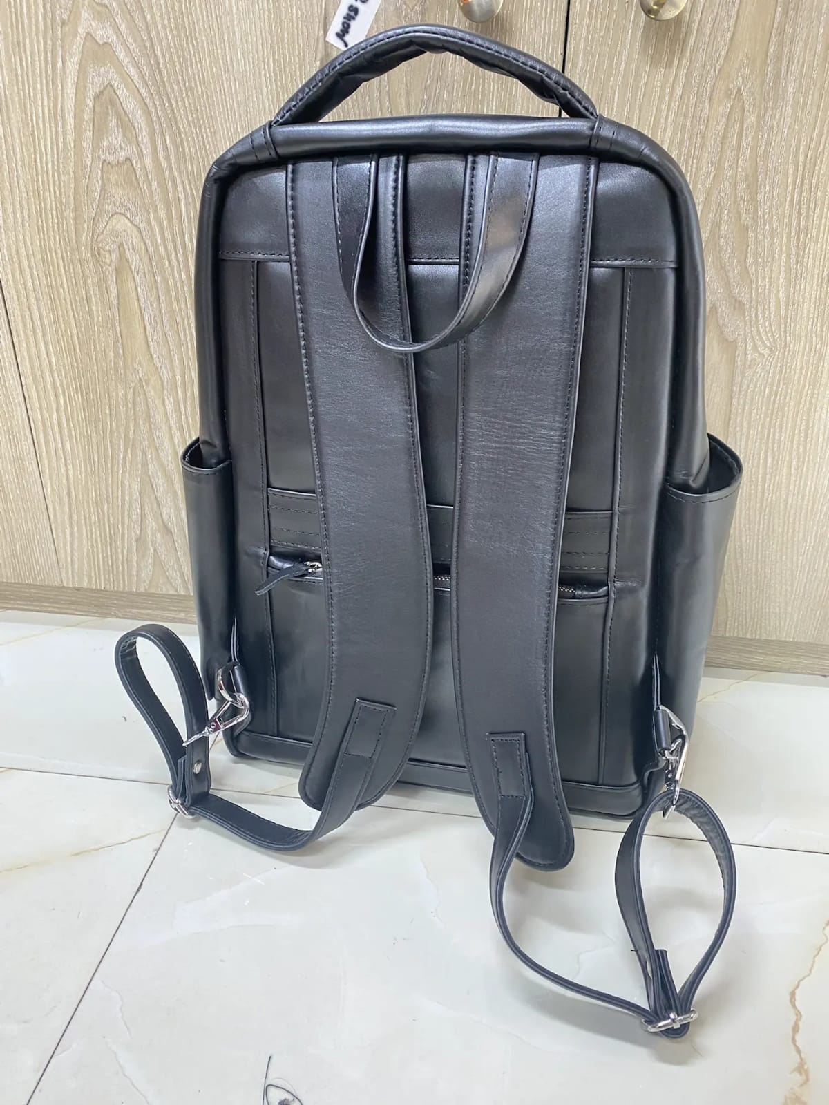 Genuine black leather laptop backpack with padded straps and side pockets Genuine black leather laptop backpack with padded straps and side pockets
