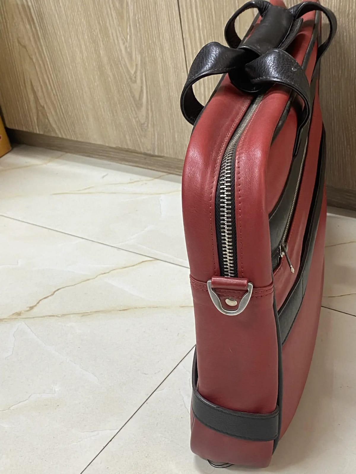 Genuine red and black leather laptop bag with zip-around opening and contrast trim