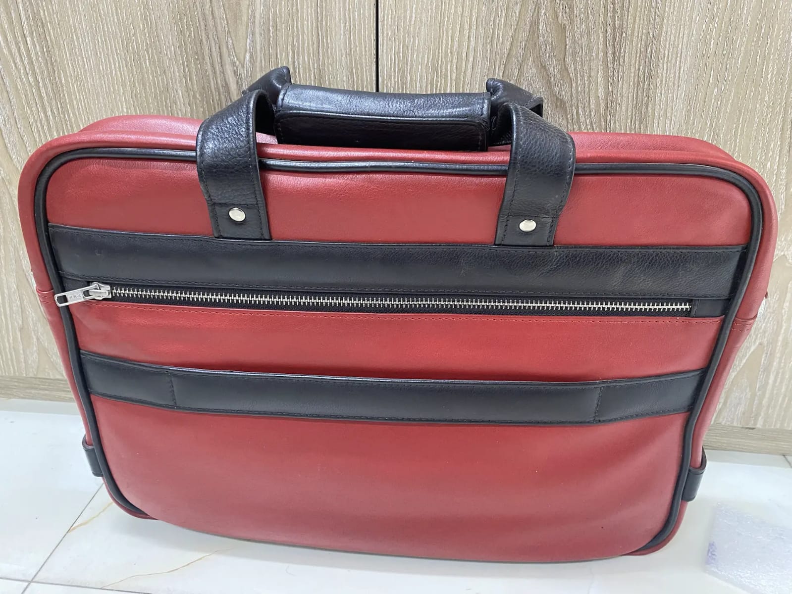 Genuine red and black leather laptop bag with zip-around opening and contrast trim