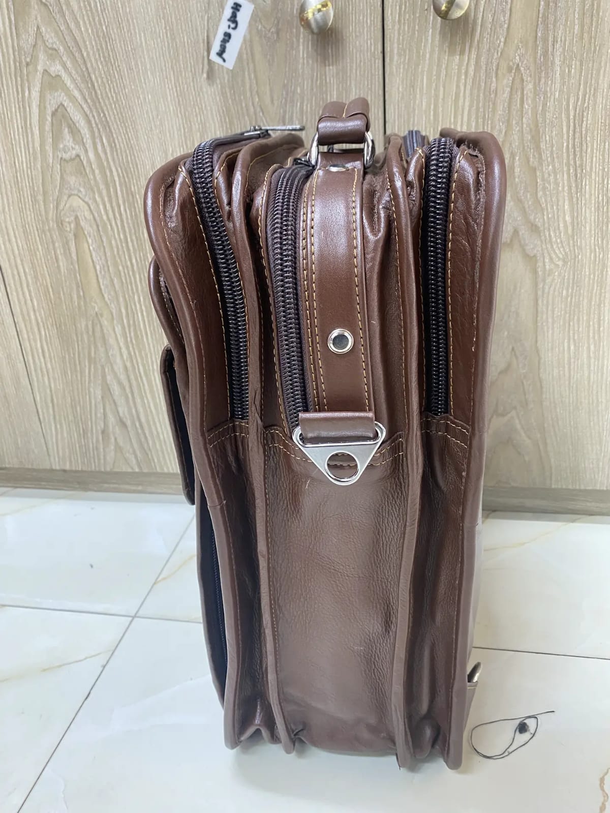 Genuine brown leather multi-pocket backpack with lock closure and adjustable straps Genuine brown leather multi-pocket backpack with lock closure and adjustable straps