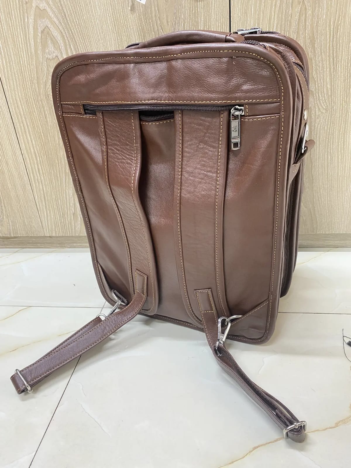 Genuine brown leather multi-pocket backpack with lock closure and adjustable straps Genuine brown leather multi-pocket backpack with lock closure and adjustable straps