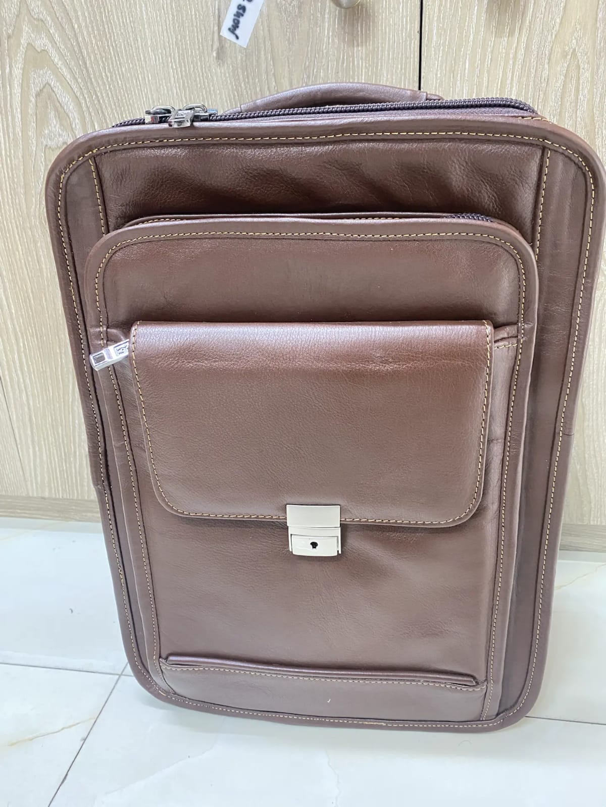 Genuine brown leather multi-pocket backpack with lock closure and adjustable straps Genuine brown leather multi-pocket backpack with lock closure and adjustable straps
